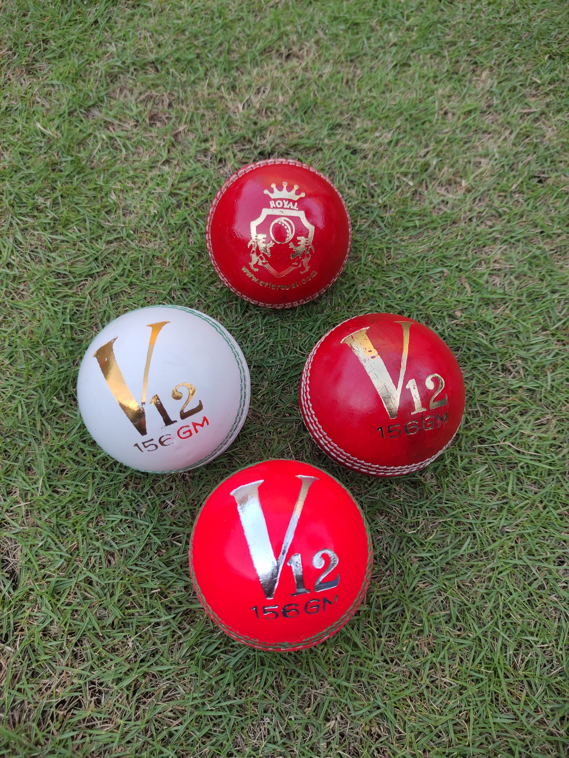 Set of 4 leather cricket balls in different colors, each displaying distinct logos including Royal Cricket and others, arranged together for a promotional showcase.