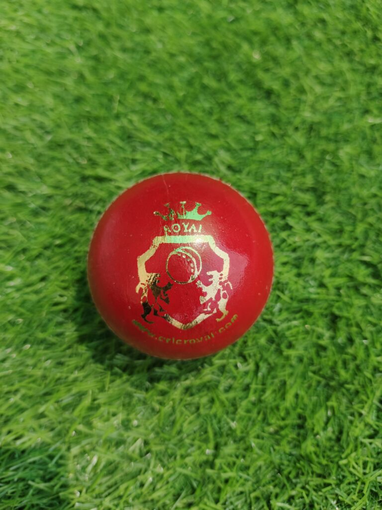 Red women-size genuine leather 4-piece cricket ball shown from front view with Royal Cricket company logo printed on top, crafted for high-quality performance with durable stitching and premium leather finish