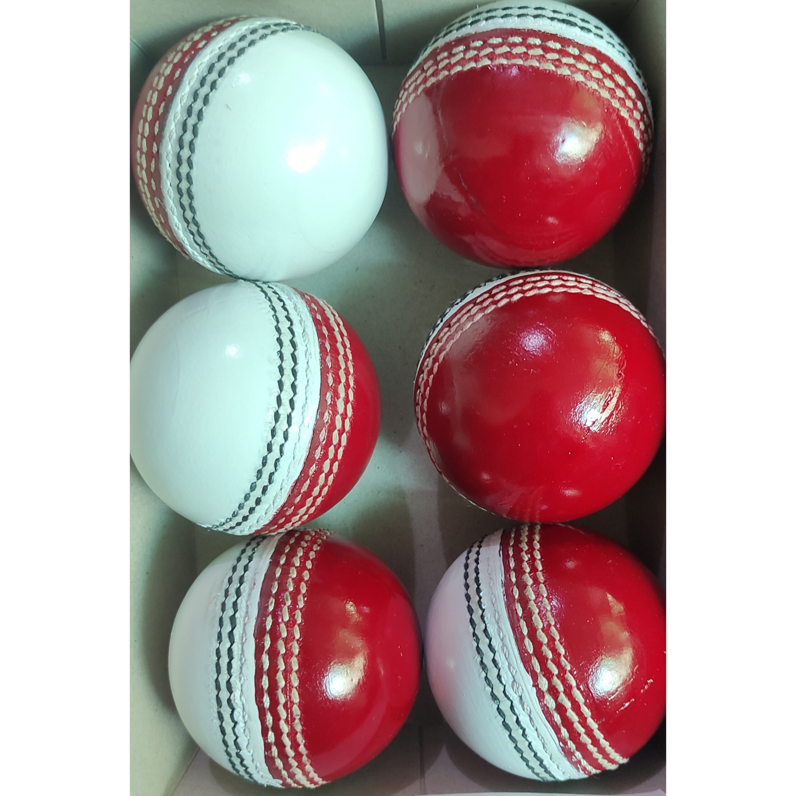 Six leather cricket balls in red and white color combination neatly arranged in a box, displayed from various angles including front and side views, ideal for coaching and practice sessions.
