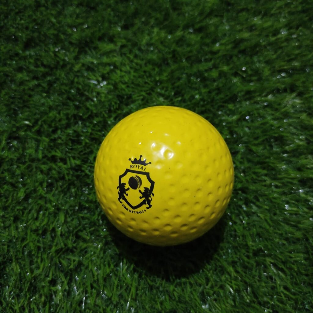 Yellow Dimple Molded Synthetic Cricket Hard Ball shown from front view with evenly spaced surface dimples for improved aerodynamics and swing performance during practice
