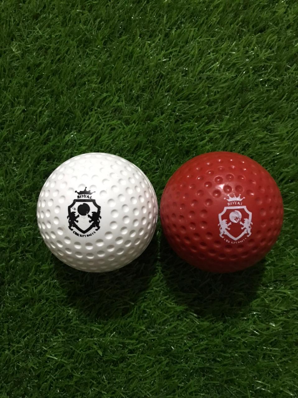 Pair of Dimple Molded Synthetic Cricket Hard Balls in red and white colors, both shown from front view with Royal Cricket logo printed clearly on the surface and dimple texture for enhanced swing control
