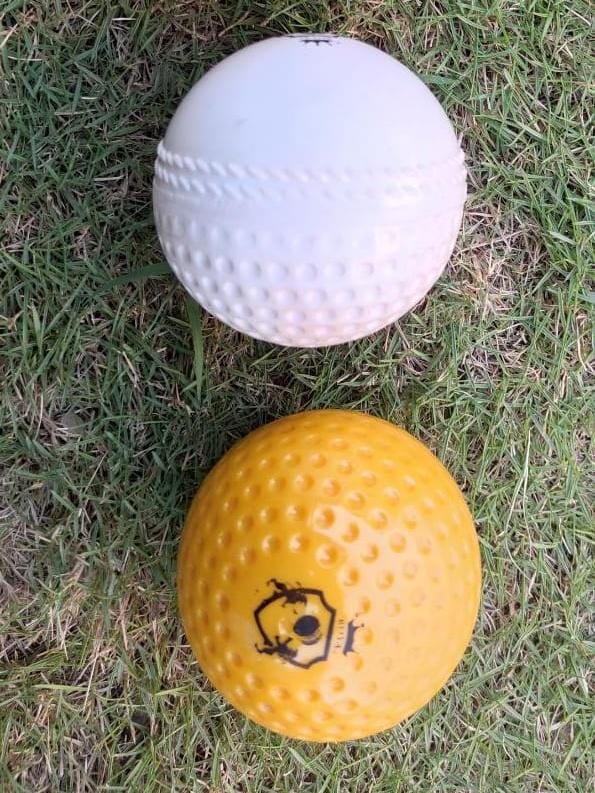 Technique Soft Swing Practice Ball | WaterProof Molded 2 Swing Practice Balls, yellow ball shown from front highlighting its plain and dimpled surface design, and white ball in side view to display profile and aerodynamic texture for swing practice